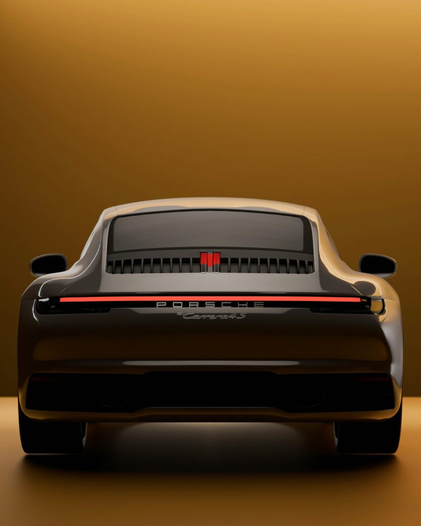 Vista trasera de un elegante Porsche Carrera de color oscuro.